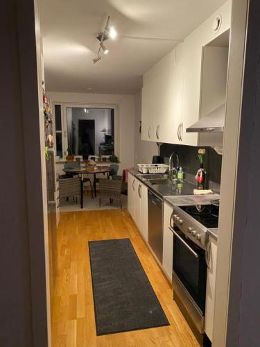 uma cozinha com um lavatório e um fogão forno superior em Cozy room in a shared apartment close to nature em Gotemburgo