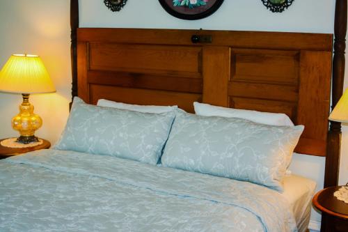 a bed with a wooden headboard and two pillows at Bed & Breakfast private room near Amish Country in Elkhart