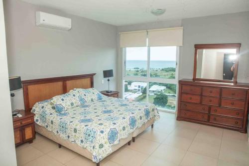 a bedroom with a bed and a dresser and a window at Founders Piso 10 in Río Hato