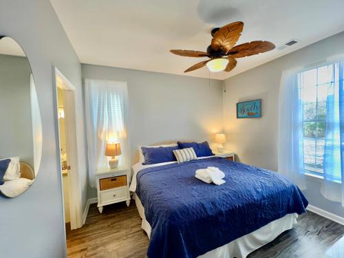 Schlafzimmer mit einem blauen Bett und einem Deckenventilator in der Unterkunft Tee Time in Myrtle Beach