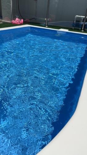 una piscina con agua azul en una habitación en شاليه هاشتاق الودي, en Al Wudayy