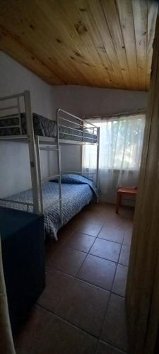 1 dormitorio con 2 literas y ventana en Cabaña azul, en Pisco Elqui