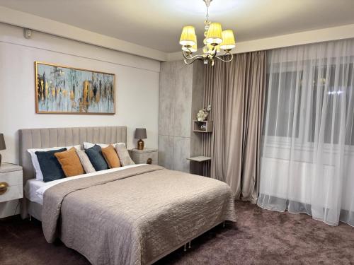 ein Schlafzimmer mit einem großen Bett und einem Kronleuchter in der Unterkunft Premium Studio MV in Sibiu