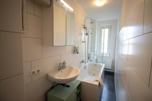 a white bathroom with a sink and a mirror at Wohnung für 5 Gäste große Küche Messe- und Citynah in Hannover