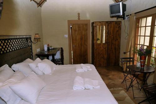 a bed with white pillows and towels on it at African Silhouette Guesthouse in Benoni