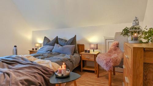 1 dormitorio con 1 cama y 1 mesa con silla en Hüs bi Söl - Haus bei Sylt, en Uphusum