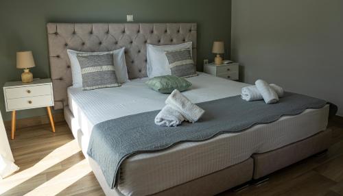 a bedroom with a large bed with two pillows at Nikitas Apartments & Suites in Kanali
