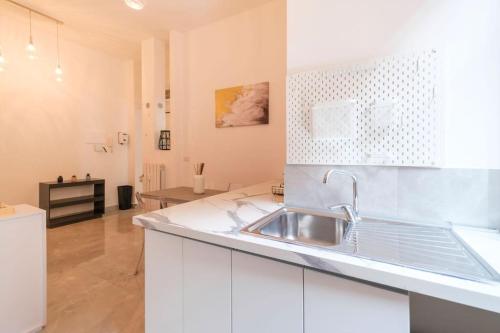 - une cuisine avec des placards blancs et un évier dans l'établissement [Cozy Double Suite] Milano Flat, à Milan