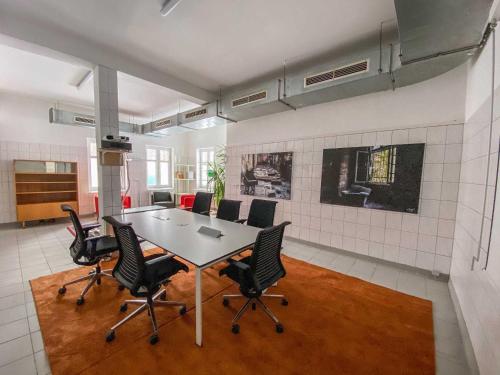 a conference room with a table and chairs at BIG MAMA Leipzig in Leipzig