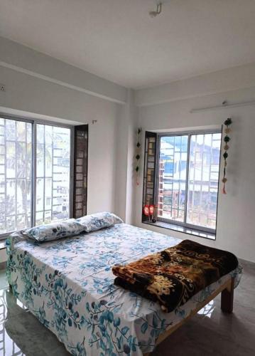 een slaapkamer met een bed met een deken erop bij Traveller's Nest By My Fav Nest in Siliguri