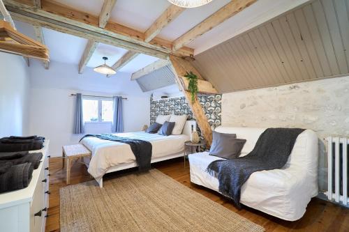 Un dormitorio con 2 camas y una silla. en Le Moulin Saint-Nicolas 