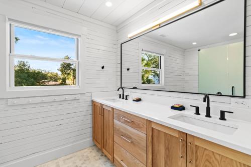 a bathroom with a sink and a large mirror at 1st Block E Hudson - Green Wave - Newly Remodeled - Pool and Hot Tub - Ideal Central Location in Folly Beach