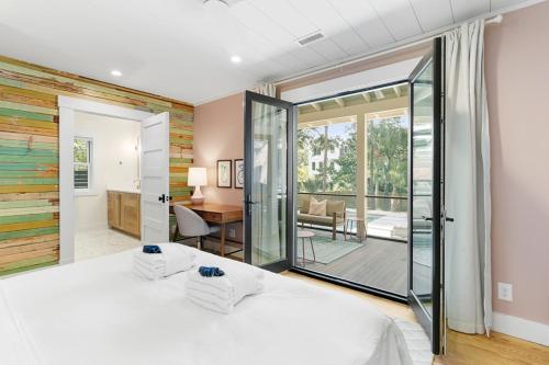 a bedroom with a white bed and a sliding glass door at 1st Block E Hudson - Green Wave - Newly Remodeled - Pool and Hot Tub - Ideal Central Location in Folly Beach