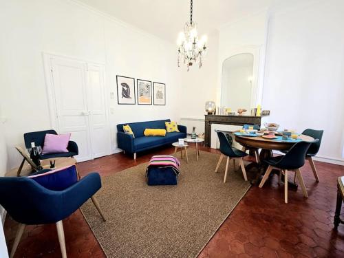 salon ze stołem i niebieską kanapą w obiekcie Le victor hugo - coeur de ville w mieście Nîmes