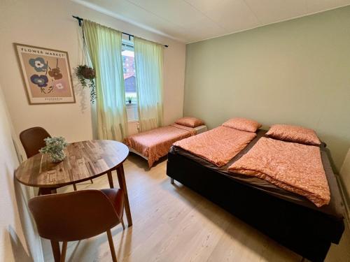a small bedroom with two beds and a table at 5 minute walk to LEGO HOUSE - Best location-Garden on site-n3 in Billund