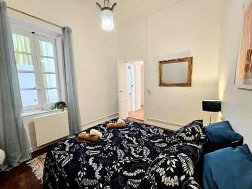 - un salon doté d'un canapé avec deux animaux rembourrés dans l'établissement Le victor hugo - coeur de ville, à Nîmes