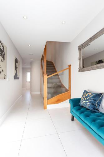 a living room with a blue couch and a staircase at Luxurious Central Windsor Town House in Windsor
