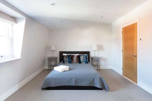 a bedroom with a bed in a white room at Luxurious Central Windsor Town House in Windsor