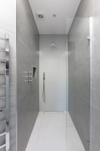 a bathroom with a shower with a glass door at Luxurious Central Windsor Town House in Windsor