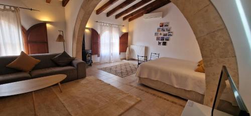 ein Wohnzimmer mit einem Bett und einem Sofa in der Unterkunft PETIT HOTEL ALGAIDA in Algaida