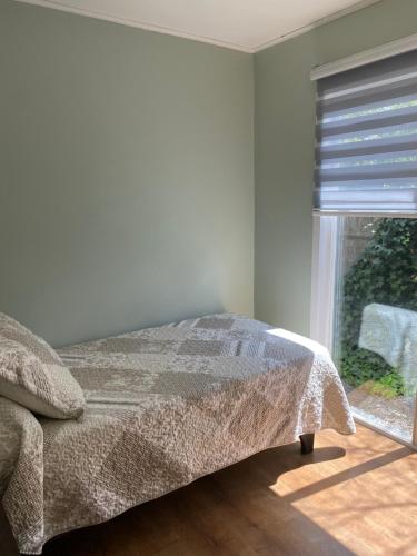 - une chambre avec un lit et une fenêtre dans l'établissement Cabañas Varas, à Osorno