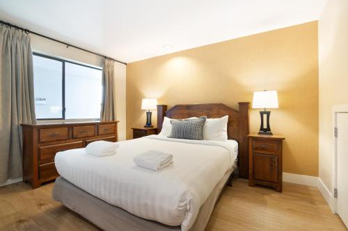 una camera da letto con un grande letto con due comodini e due lampade di Powder's Edge by LaTour Hotels and Resorts a Whistler