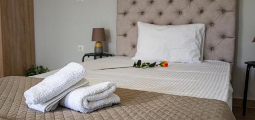 a bedroom with a bed with towels on it at Nikitas Apartments & Suites in Kanali