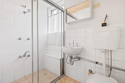 a white bathroom with a sink and a shower at 2 Bedroom Unit in Liverpool Sleeps 4 in Liverpool
