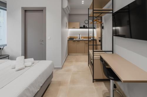 a bedroom with a white bed and a kitchen at ELA FIVE RESIDENCES in Athens