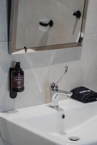 a bathroom sink with a soap dispenser on it at ELA FIVE RESIDENCES in Athens