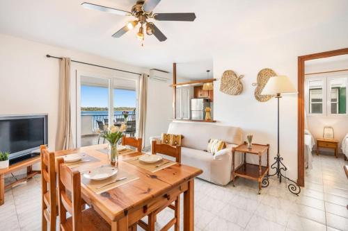 a dining room and living room with a table and a couch at Gabriel Sans apartment Fornells in Fornells