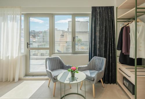 a room with two chairs and a table and a window at ELA FIVE RESIDENCES in Athens