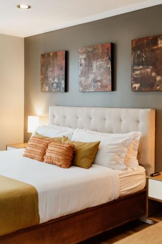 a bedroom with a large white bed with pillows at Casa Asturias in Ensenada