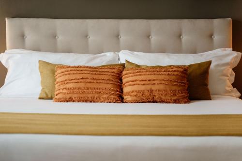 a bed with four pillows and a headboard at Casa Asturias in Ensenada