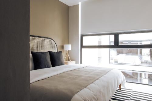 a bedroom with a large bed and a large window at MINERIA By Mr W in Mexico City