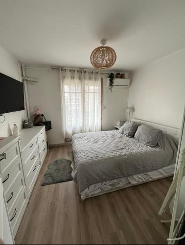 - une chambre avec un lit, une commode et une télévision dans l'établissement En face du vélodrome, à Marseille