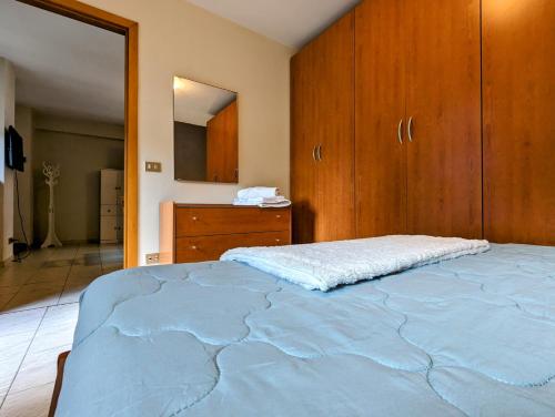 1 dormitorio con 1 cama grande y armarios de madera en Fontana Home en Domodossola