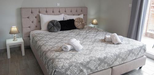 a bedroom with a bed with two dogs laying on it at Nikitas Apartments & Suites in Kanali
