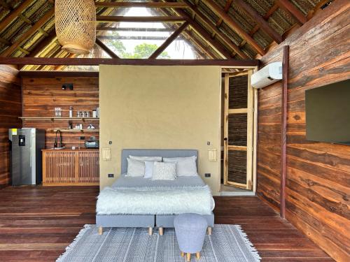 a bedroom with a bed in a room with wooden walls at Cabaña Vista al Mar Tayrona, A/C in Los Naranjos
