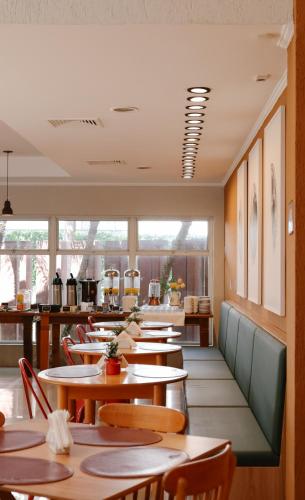 a row of tables and chairs in a restaurant at Carlton Plaza Baobá in Taubaté