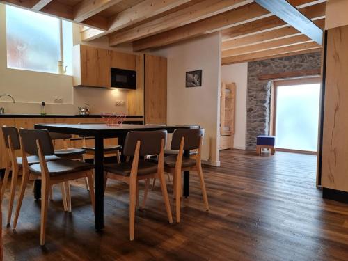une cuisine et une salle à manger avec une table et des chaises dans l'établissement La MaiZon du Bois 1 er étage, à Champagny-en-Vanoise