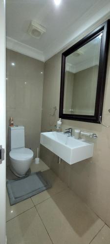 ein Badezimmer mit Toilette, Waschbecken und Spiegel in der Unterkunft Accommodation Front - Relaxing 2 Sleeper near Ushaka Marine World in Durban