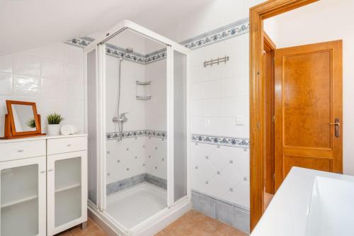 a white bathroom with a shower with a glass door at Villa Sea Garden Holidays in Port d'Addaia