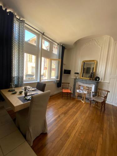 uma sala de estar com uma mesa e cadeiras e uma lareira em Le Jean Jaurès em Troyes