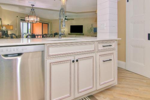 a kitchen with white cabinets and a sink at Reef Club 307 in Clearwater Beach