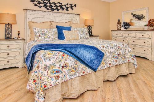 a bedroom with a bed and two dressers at Reef Club 307 in Clearwater Beach