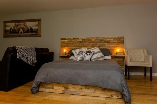 a bedroom with a large bed and a chair at Condo Hotel Au pied du Mont Orford in Orford