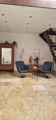 a living room with two chairs and a table at Huize Dijkwater in Dreischor