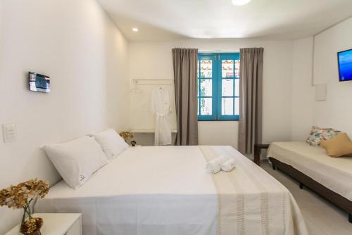 ein weißes Schlafzimmer mit einem Bett und einem Sofa in der Unterkunft CASA ORGANIC in Caucaia
