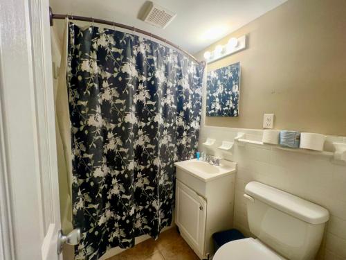 uma casa de banho com um WC e uma cortina de chuveiro em preto e branco em Coco Loco em Myrtle Beach